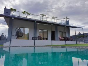 a house with a swimming pool next to a house at AG Villa in Neral