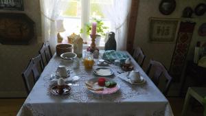 a table with a white table cloth with food on it at Albertsgårdens Bed & Breakfast i Norra Häljaröd in Farhult