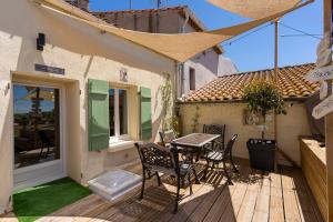 a patio with a table and chairs on a deck at Logement féerique SPA & terrasse - proche Pézenas in Abeilhan