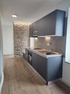 a kitchen with black cabinets and a sink at Erica in Folgaria