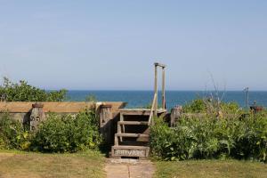 a wooden staircase with the ocean in the background at Historic Railway Home - Selsey Seafront in Selsey +47 photos