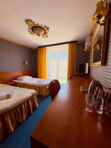 a hotel room with two beds and a large table at Szafir in Rzeszów