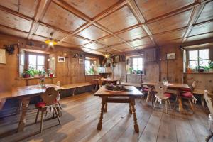 a dining room with wooden floors and tables and windows at Schnatzhof Apartment Schwalbennest in Naturno