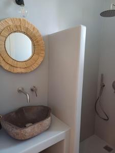 a bathroom with a stone sink and a mirror at Ραχάτι in Áyios Stéfanos +14 photos