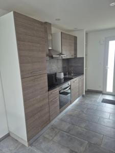 Una cocina con gabinetes de madera y encimera. en Gite de l'usine, en Roussay