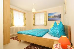 une chambre avec un lit avec des oreillers bleus dessus dans l'établissement Ferienhaus Hermann, à Schladming
