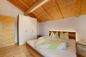 a bedroom with a bed and a wooden ceiling at Schnatzhof Apartment Schwalbennest in Naturno