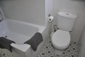 a bathroom with a white toilet and a bath tub at Casa Dulce in Vejer de la Frontera