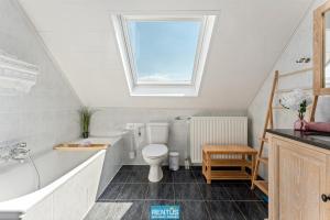 un bagno con un water, un lavandino e una finestra di Groenhage - enjoy peace in the heart of Leffinge a Middelkerke Altre 20 foto