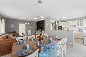 una sala da pranzo e un soggiorno con tavolo e sedie di Groenhage - enjoy peace in the heart of Leffinge a Middelkerke