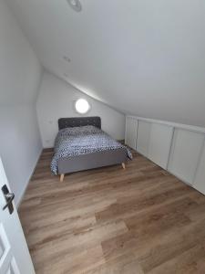 Un dormitorio con una cama y suelo de madera. en Gite de l'usine, en Roussay