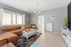 un soggiorno con un divano e un tavolo di Groenhage - enjoy peace in the heart of Leffinge a Middelkerke