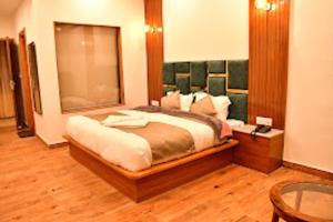a bedroom with a large bed and a table at Hotel Mountain Majesty's Inn, Manāli in Manāli