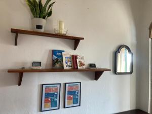 a shelf with books and pictures on a wall at Appartamento sul Mare in Marina di Massa
