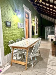 Ein Holztisch und Stühle vor einer grünen Wand in der Unterkunft Casa Quinta Villa Anita in San Pedro + 23 Fotos