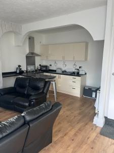 a living room with a couch and a kitchen at Bradford Homely House in Bradford
