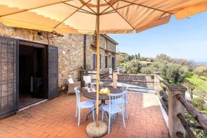 eine Terrasse mit Tisch, Stühlen und Sonnenschirm in der Unterkunft Bellezza In Cilento Panoramic Apts in Castellabate