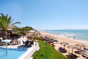 uma praia com cadeiras e guarda-sóis e o oceano em ROBINSON KYLLINI BEACH - All Inclusive em Kyllini