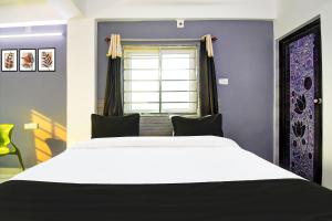 a bedroom with a large white bed and a window at Hotel O Kalyani Golden Key in Bālianta