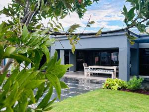 una casa con un banco en el patio en Pula Nala Lodge Bed & Breakfast, en Rustenburg