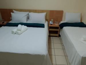 two beds in a hotel room with towels on them at Flat Rio Quente 110-A in Rio Quente