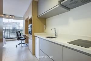 eine Küche mit Spüle und einem Schreibtisch mit Stuhl in der Unterkunft Studio Moderno a 450m do Metrô – ISM0806 in São Paulo