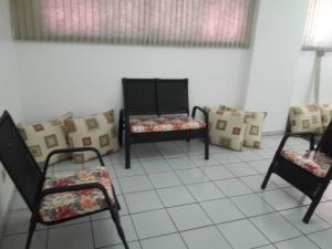 a living room with two chairs and pillows at Flat Di Roma 110A Rio Quente in Rio Quente