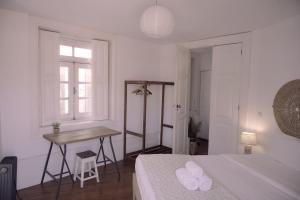 a white bedroom with a desk and a bed at Light & Airy Historic Centre House with Balconies in Porto