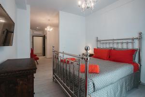 una camera da letto con letto in metallo con cuscini rossi di Athens Point ad Atene