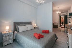 una camera da letto con un letto con due cuscini rossi sopra di Athens Point ad Atene