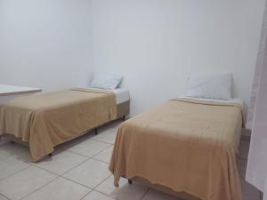 two beds sitting next to each other in a room at Cantinho da LAGO in Itacuruçá