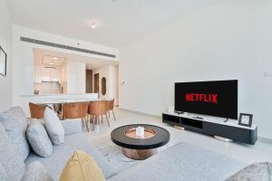salon z kanapą i telewizorem w obiekcie Grand 3BR APT with Pool, Gym and 2 Parking Spaces w Dubaju