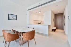 迪拜Grand 3BR APT with Pool, Gym and 2 Parking Spaces的厨房以及带桌椅的用餐室。 更多33张照片
