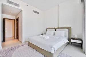 Łóżko lub łóżka w pokoju w obiekcie Grand 3BR APT with Pool, Gym and 2 Parking Spaces