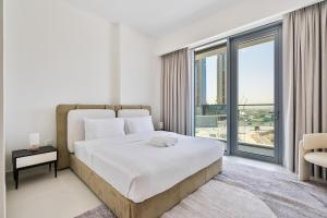 迪拜Grand 3BR APT with Pool, Gym and 2 Parking Spaces的一间带大床和大窗户的卧室