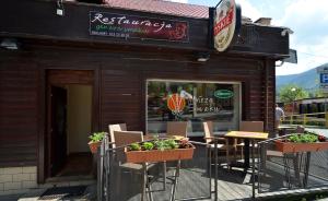 een restaurant met stoelen en planten ervoor bij Apartamenty i Pokoje Karpacz - centrum Karpacza, parking w cenie! in Karpacz