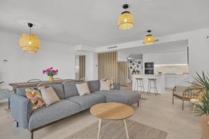 a living room with a blue couch and a kitchen at Townhouse Eden Golf Chaparral in Málaga