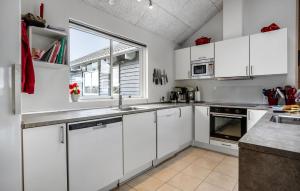 a white kitchen with white cabinets and a window at Stunning Home In Bogense With Sauna in Skåstrup