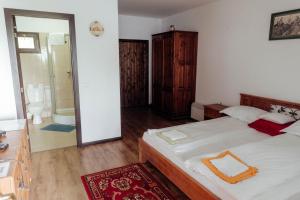 a bedroom with a large bed and a bathroom at Hanul Pescarilor Crisan in Tulcea