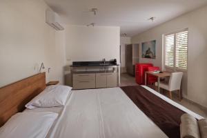 a bedroom with a large bed and a kitchen at Chogogo Dive & Beach Resort Curaçao in Jan Thiel +49 photos