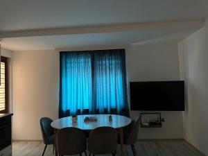 a dining room with a table and a blue curtain at Apartments Carpe Del Mare Complex Carpe Diem Balchik in Balchik
