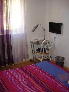 a bedroom with a desk and a bed and a chair at BnB Le Relais du Château in Aigle