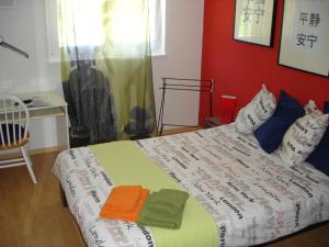 a bed in a room with a red wall at BnB Le Relais du Château in Aigle