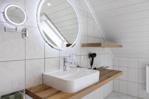 a bathroom with a sink and a mirror at Ferienwohnung Rhön-Kutscher in Buttlar +22 photos