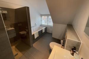 a bathroom with a toilet and a tub and a sink at de Binnenhof by Droomvilla in Vriezenveen +29 photos