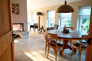 a dining room with a table and chairs and a fireplace at de Binnenhof by Droomvilla in Vriezenveen