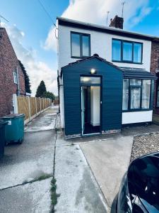 une maison avec un hangar bleu sur le côté dans l'établissement The Cozy Stay House, à Langley Mill