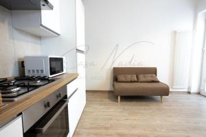 a kitchen with a stove and a couch in a room at Nadia Apartment in Chioggia +5 photos