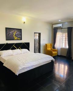 Mamaにあるjazmine suitesのベッドルーム(大型ベッド1台、黄色い椅子付)