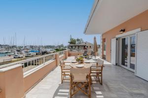 a patio with tables and chairs on a balcony with a marina at Christina's apartment 2 in Kontokali